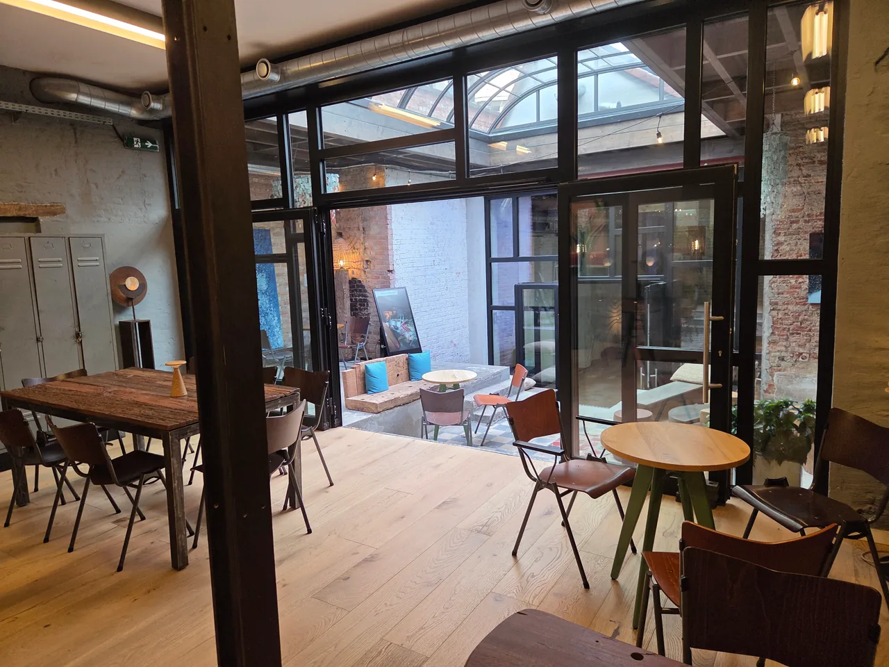 Tables and chairs beside the glass doors to Artisan’s courtyard in Kortrijk.