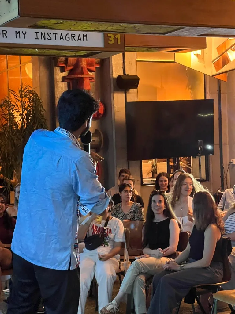 WOLF Sharing Food Market — comedian with microphone and front-row crowd